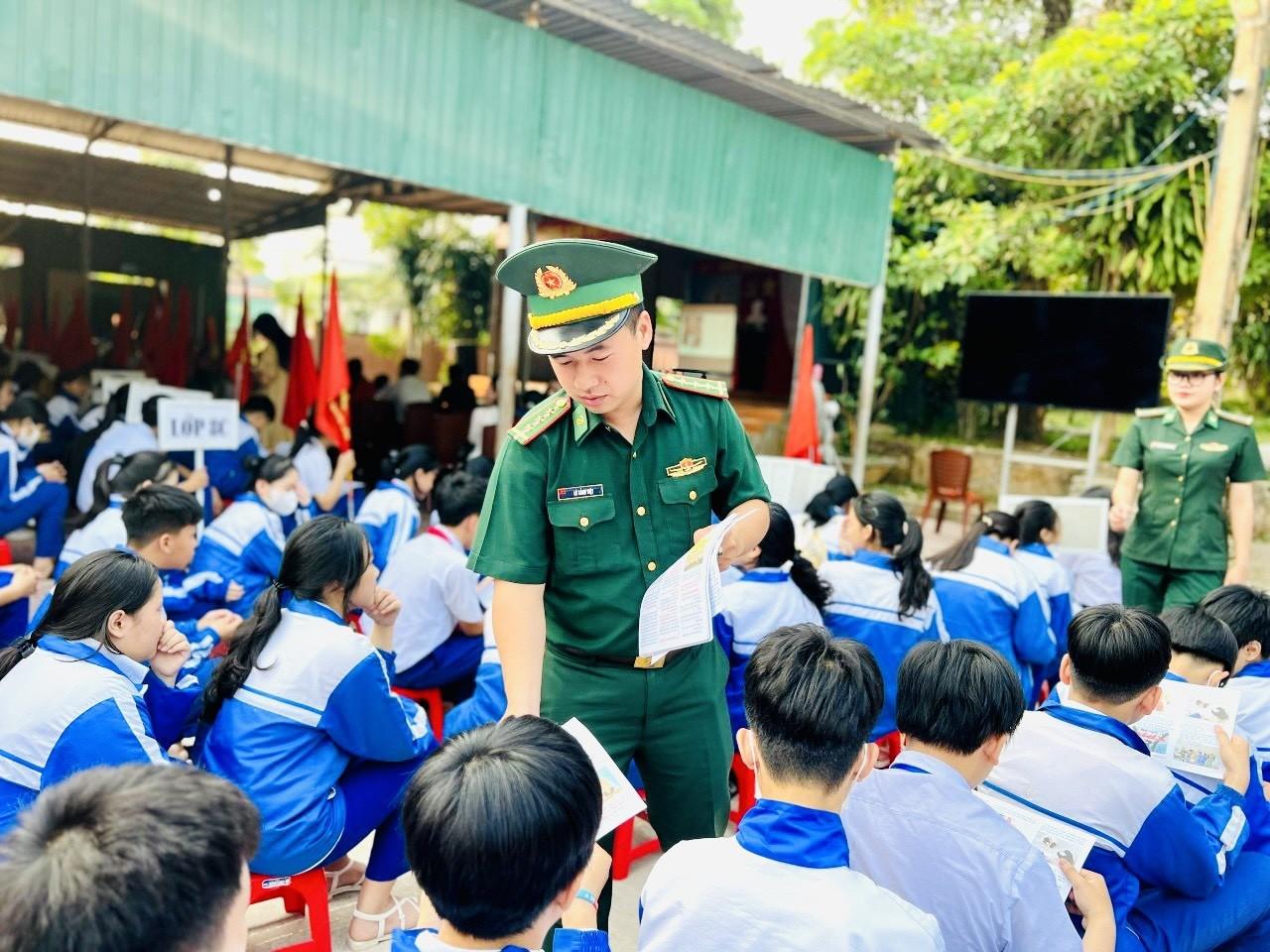Cán bộ Đồn Biên phòng CKQT Lao Bảo phát các tờ rơi cho học sinh về phòng, chống ma túy và tệ nạn xã hội.