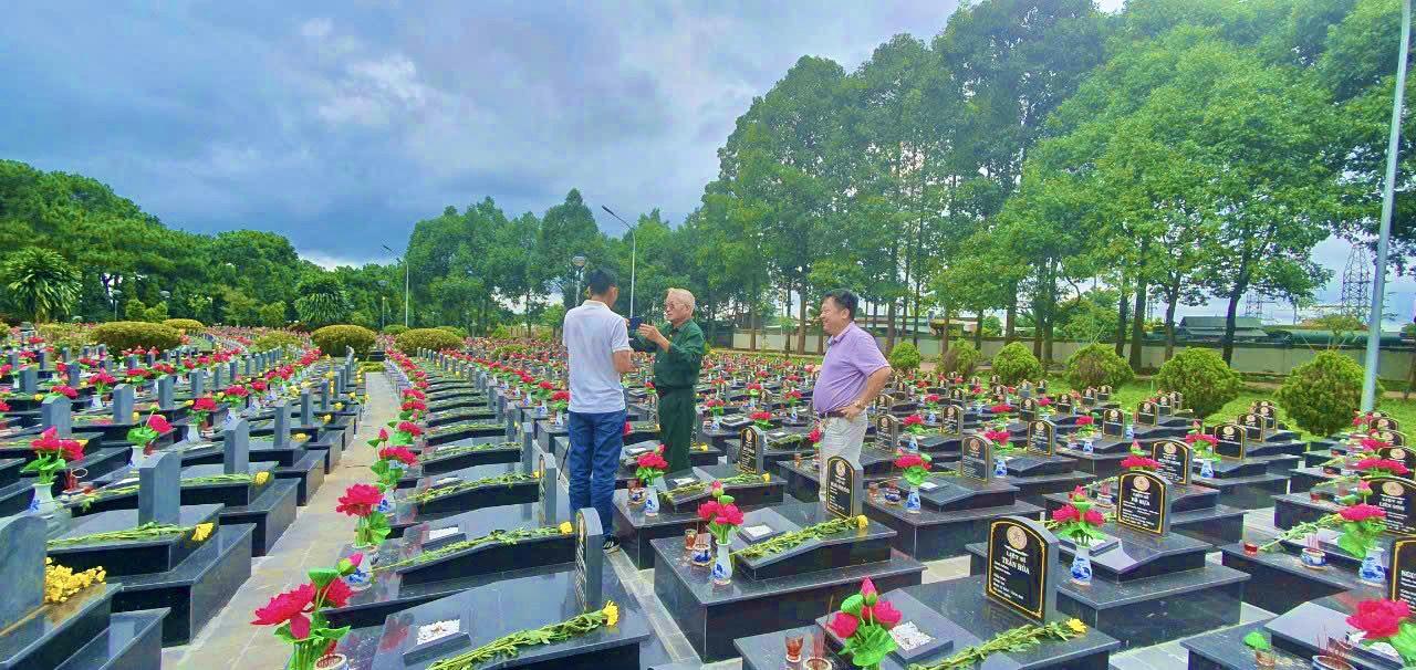 Cựu chiến binh và du khách thăm nghĩa trang liệt sĩ.