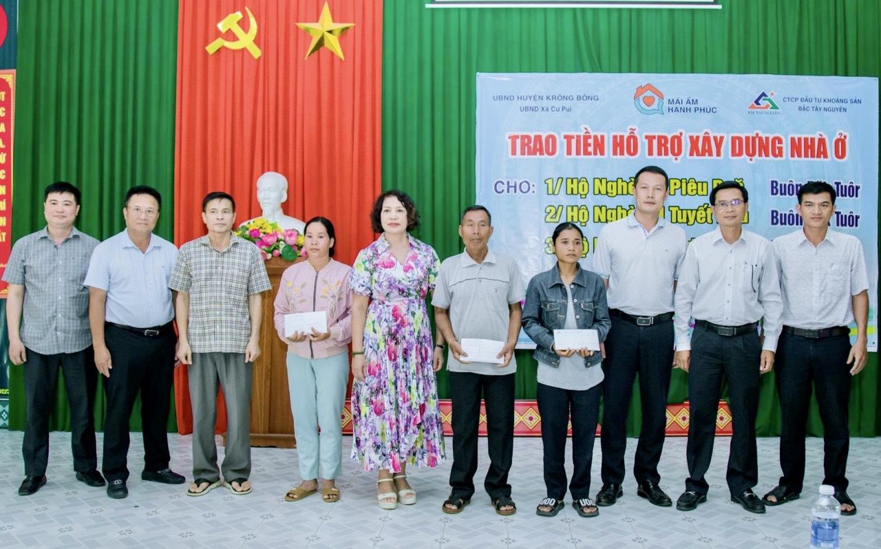Lãnh đạo huyện Krông Bông và các đơn vị trao tiền hỗ trợ cho các hộ nghèo tại xã Cư Pui.