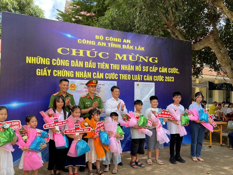 Đại diện lãnh đạo Công an tỉnh và thị xã Buôn Hồ tặng quà cho trẻ em dến làm căn cước.