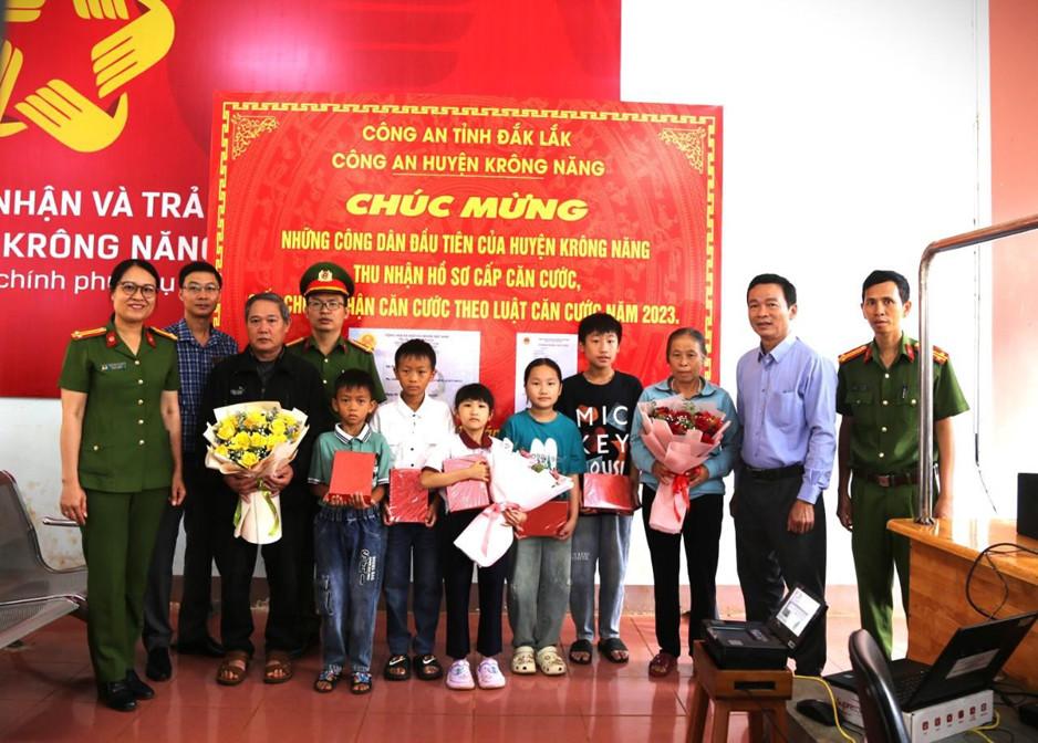 Đại diện lãnh đạo Công an Huyện Krông Năng tặng quà cho trẻ em và công dân dến làm căn cước.