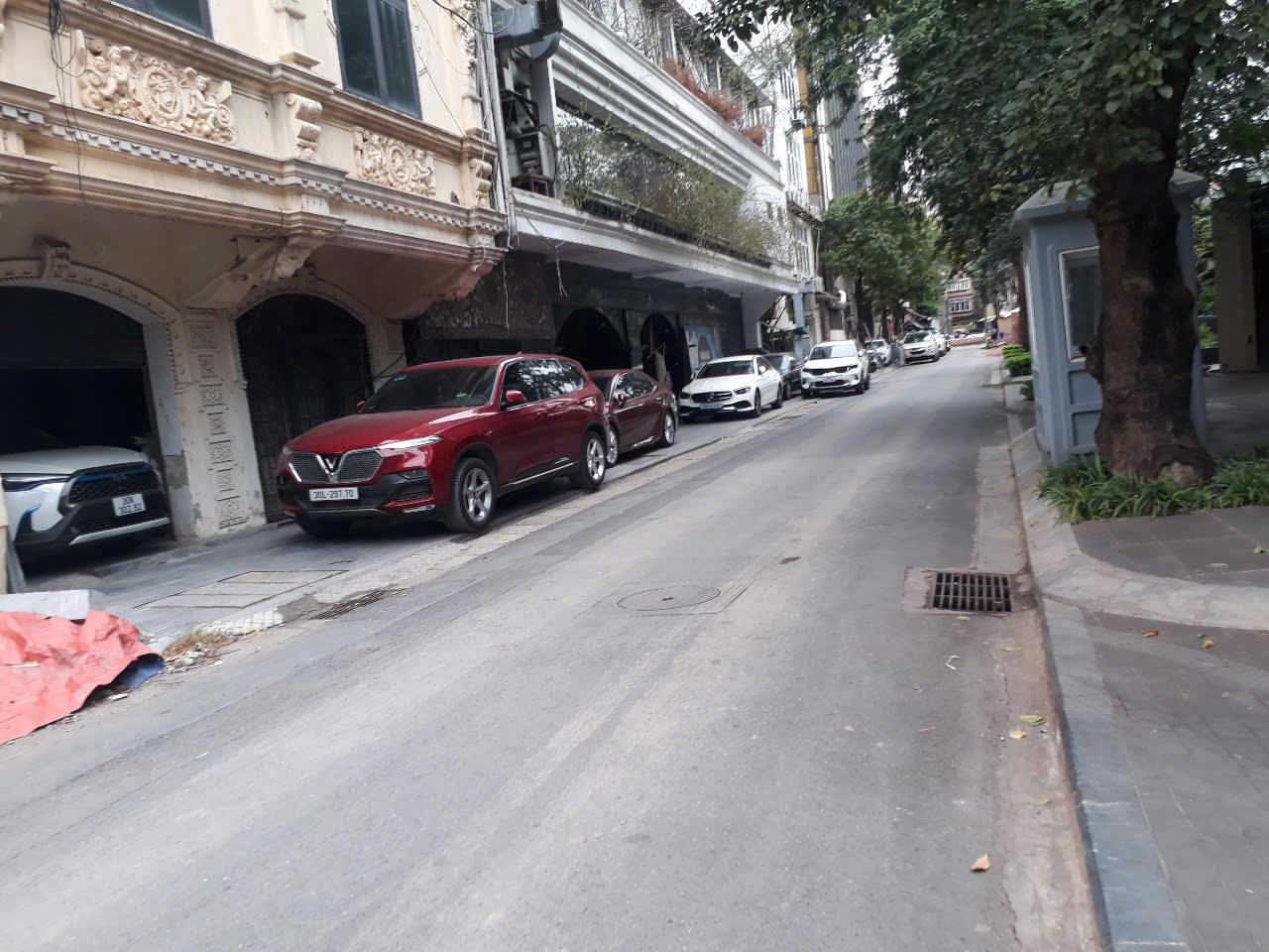 Ở phía đối diện tòa nhà, các xe ô tô của dãy nhà đối diện phải để lên vỉa hè để lấy lối đi.