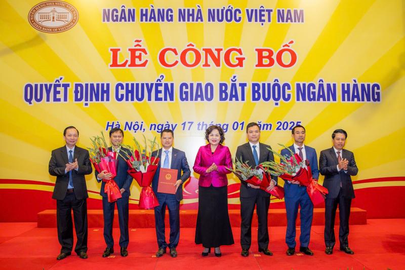 Thống đốc Nguyễn Thị Hồng trao quyết định chuyển giao bắt buộc cho các tổ chức tín dụng.