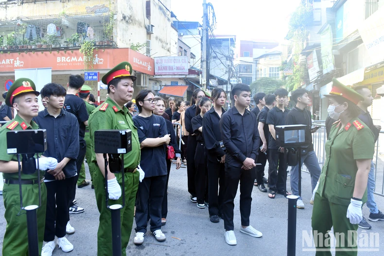 Lực lượng công an hướng dẫn người dân xếp hàng, làm thủ tục để vào viếng Tổng Bí thư Nguyễn Phú Trọng.