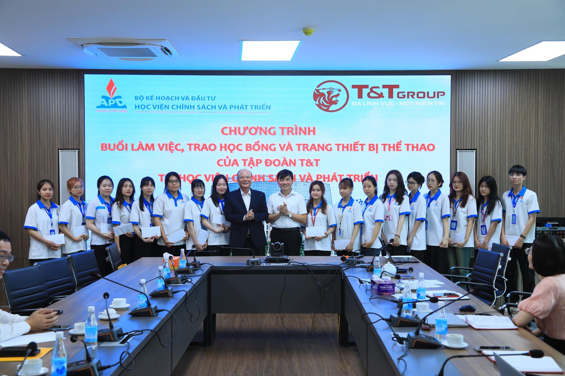 Ông Nguyễn Tất Thắng và ông Trần Trọng Nguyên chụp ảnh cùng các em học sinh tại Học viện Chính sách và Phát triển.