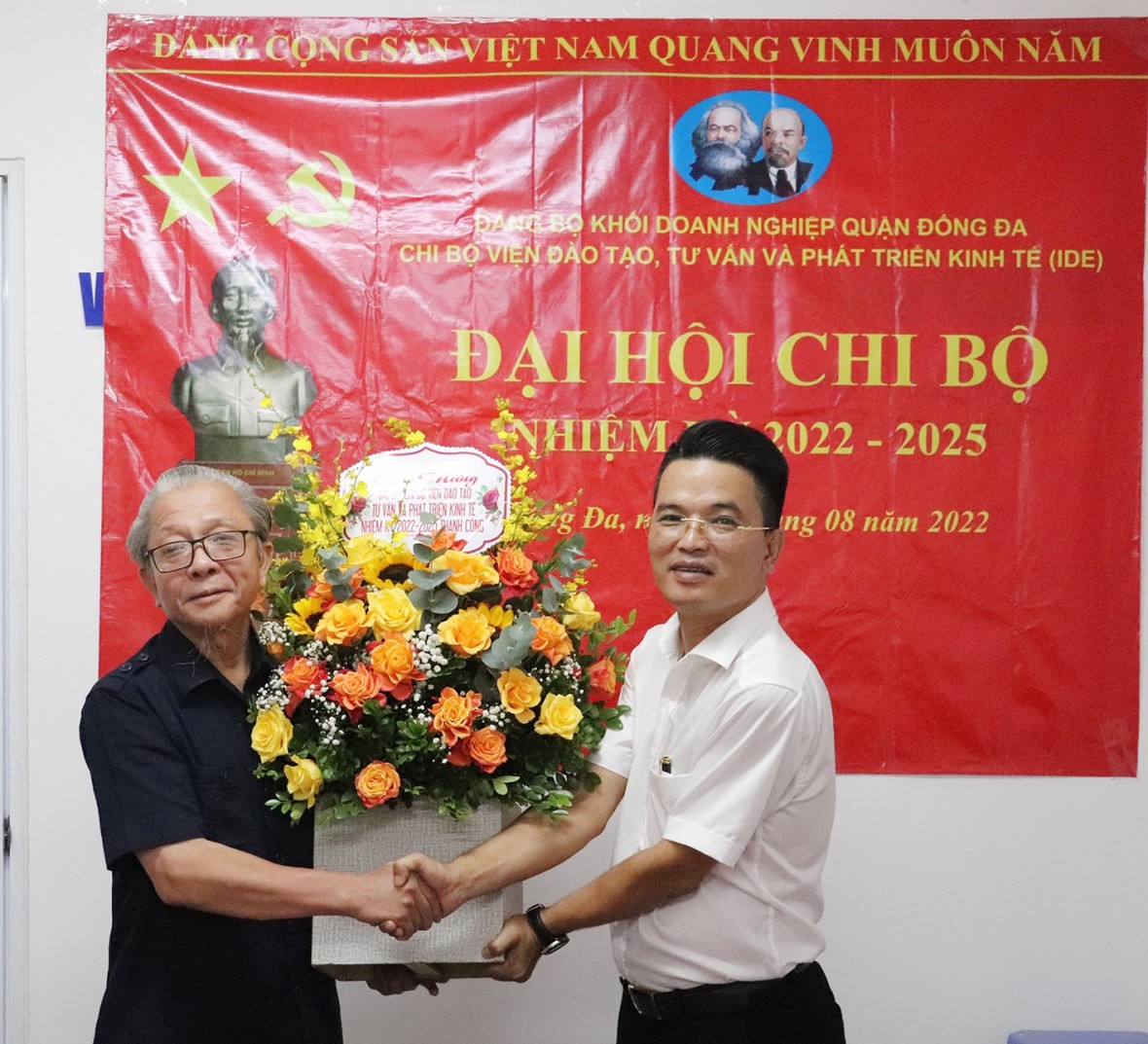 Ông Nguyễn Quốc Hải, Viện trưởng Viện Đào tạo, Tư vấn và Phát triển kinh tế (trái) tặng hoa chúc mừng Đại hội.