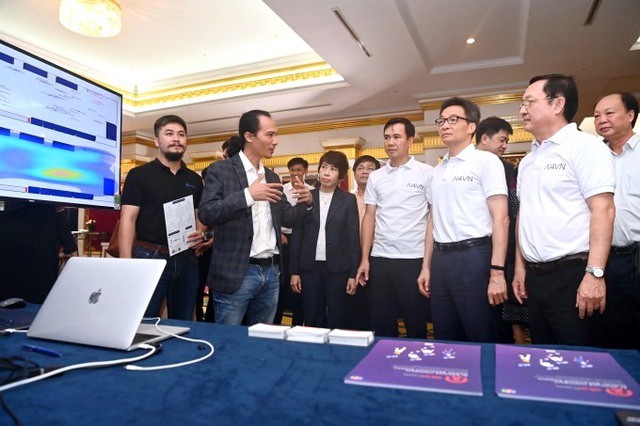 Phó Thủ tướng Vũ Đức Đam và Bộ trưởng Bộ KH&CN Huỳnh Thành Đạt tham quan và trải nghiệm các sản phẩm tại triển lãm trong khuôn khổ Ngày hội AI Việt Nam - Ảnh: VGP