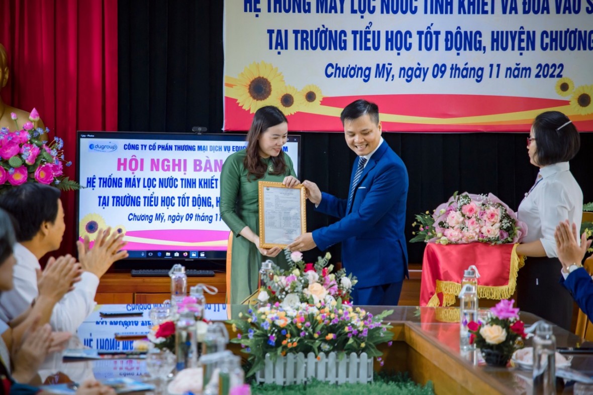 Ông Trịnh Văn Mười- Tổng Giám Đốc Edugroup đang bàn giao chứng nhận kiểm định chất lượng nước cho nhà trường.