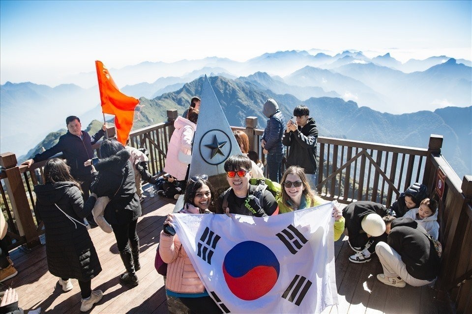 Khách nước ngoài thích thú khi chụp ảnh trên đỉnh Fansipan (Sapa, Lào Cai). Ảnh: T.Hà