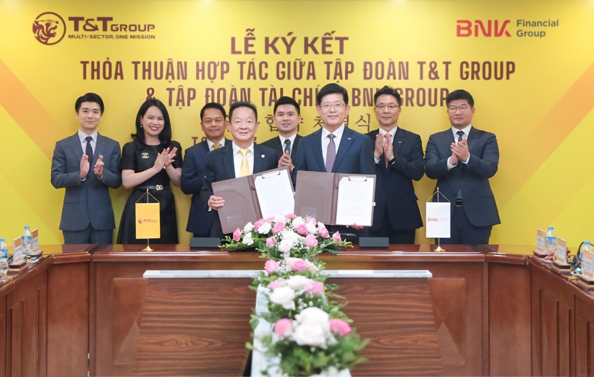 Ông Đỗ Quang Hiển, Chủ tịch UBCL Tập đoàn T&T Group (bên trái) và ông Bin Dae-in, Chủ tịch HĐQT kiêm TGĐ Tập đoàn Tài chính BNK (bên phải) trao thỏa thuận hợp tác với sự chứng kiến của đại diện lãnh đạo hai Tập đoàn